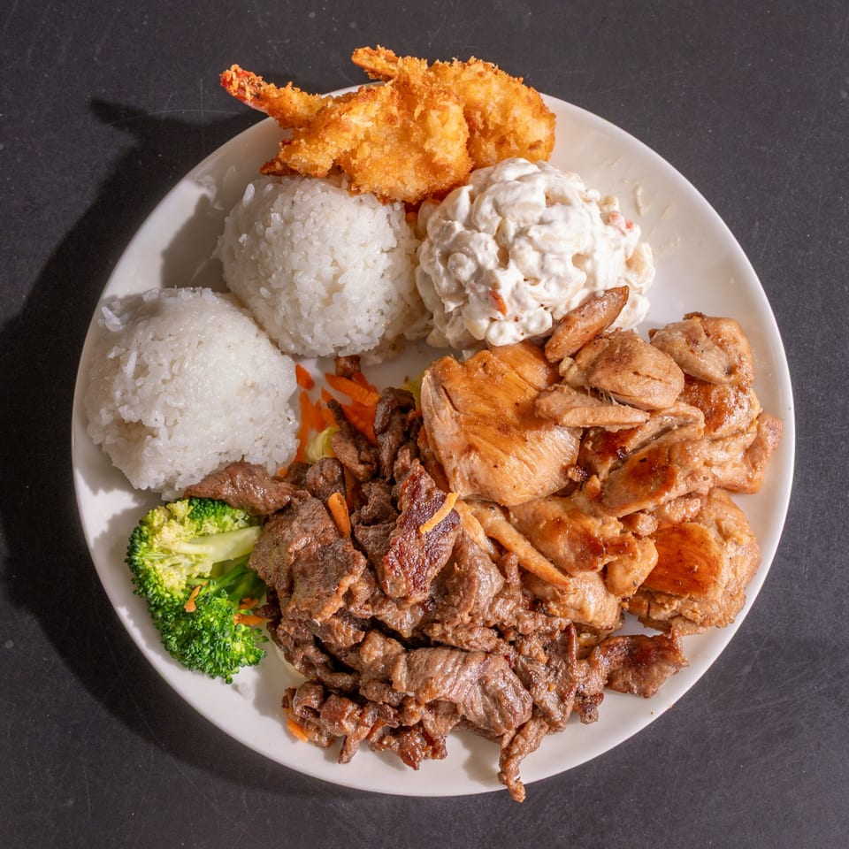 A plate of Hawaiian BBQ chicken and beef, with rice, macaroni salad, and fried shrimp.